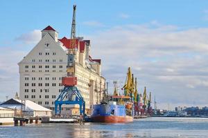 Moored ships and harbor cranes in port photo