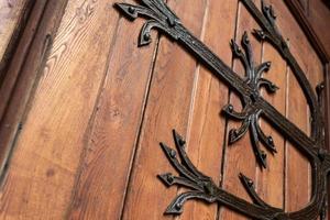 patrón de puerta forjada, decorativa. antigua entrada vintage, enorme puerta de madera pesada de iglesia o catedral. foto