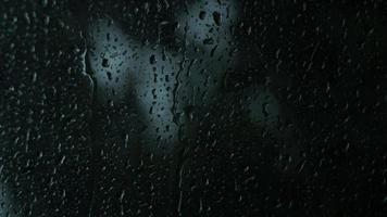 regn droppar på de glas. små regndroppe vilar på glas medan regnar. video
