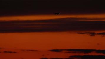 el avión en la aproximación final antes de aterrizar en el fondo del cielo del atardecer video