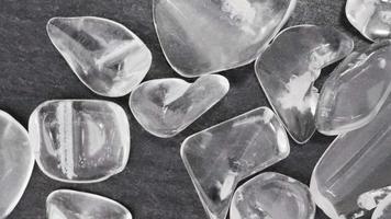 Clear quartz jewel heap on black stone background. Moving right seamless loop backdrop. video