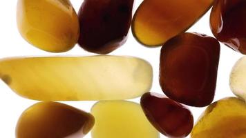 Yellow Agate heap up jewel texture on white light isolated background. Moving right seamless loop backdrop. video