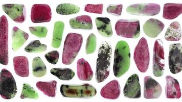 Ruby zoisite jewel stones set texture on light white isolated background. Macro closeup. Moving right seamless loop backdrop. video