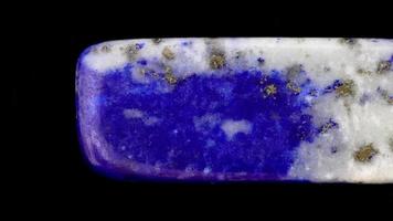 lapis lazuli juvel sten textur på svart bakgrund. makro närbild. rör på sig rätt sömlös slinga bakgrund. video