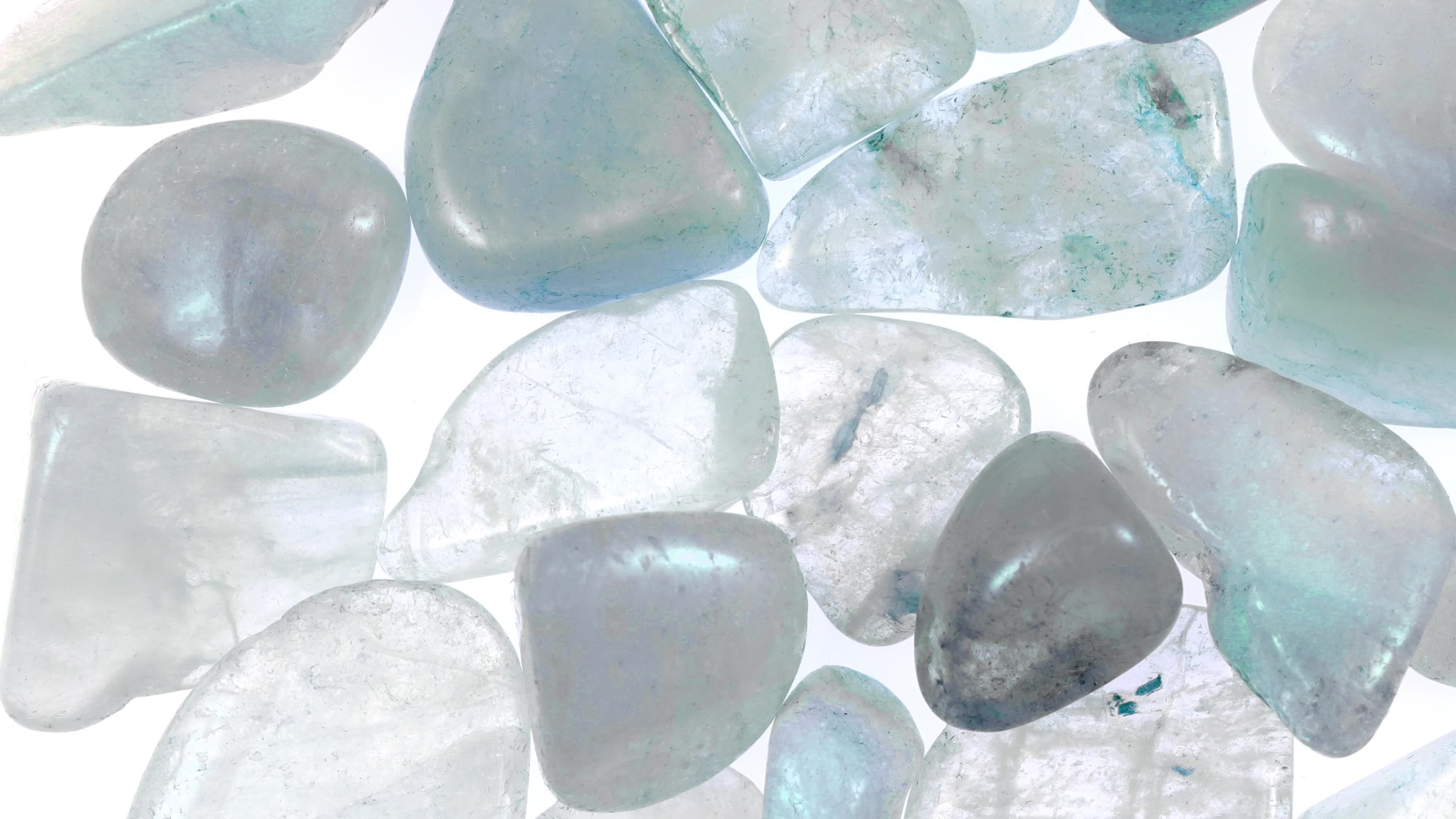 Aquamarine heap jewel stones texture on white light background. Moving