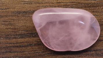 Rose quartz jewel stone texture on black stone background. Macro closeup. Moving right seamless loop backdrop. video