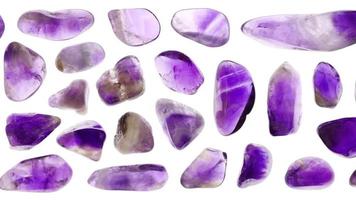 Amethyst jewel stones set texture on light white isolated background. Macro closeup. Moving right seamless loop backdrop. video