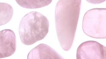 Rose quartz jewel texture on light surface background. Scarce mineral pebbles creative. Moving right seamless loop backdrop. video