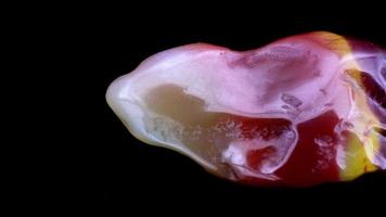 Yanyuan agate jewel stone texture on black background. Macro closeup. Moving right seamless loop backdrop. video