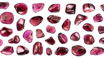 Garnet jewel stones set texture on light white isolated background. Macro closeup. Moving right seamless loop backdrop. video