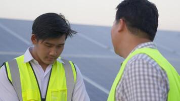 o jovem engenheiro-chefe reclama do estagiário no local da usina de energia solar, painel solar em segundo plano video