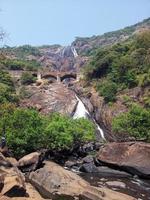 Beautiful view of Dudhsagar waterfall in Goa, India. Railway bridge above the waterfall photo