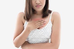 A woman suffering from heartburn on a gray background. photo