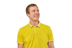 Portrait of funny young guy in yellow T-shirt looking right isolated on white background photo