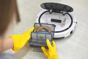 Robot vacuum cleaner, taking out filter, cleaning. Close up. photo