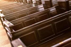 Cathedral pews. Rows of benches in christian church. Heavy solid uncomfortable wooden seats. photo