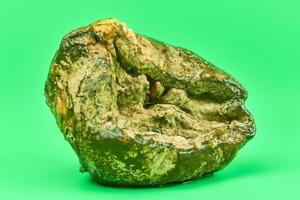 Rotten lemon, green background photo