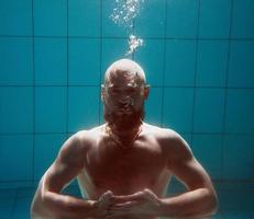 athletic sport man underwater in the swimming pool. Sports, yoga, free diving concept photo