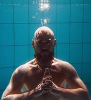 hombre de deporte atlético bajo el agua en la piscina. deportes, yoga, concepto de buceo libre foto