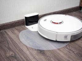 robotic vacuum cleaner on a laminated wooden floor Charging dock station.