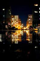 Night life, modern buildings of the capital with the reflection of light in puddles. photo