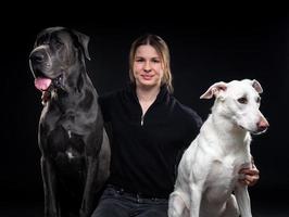 young pretty woman posing with her pets, on a black background. photo