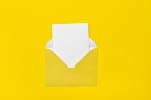 sobre amarillo abierto sobre un fondo amarillo con una nota dentro. lugar para su texto. servicio de entrega. foto