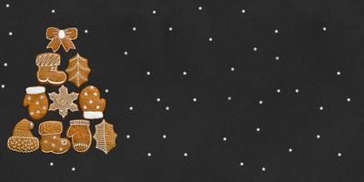 Christmas tree made up of gingerbread cookies on a black background with stars. Place for your text photo