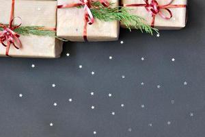 gifts and scattered glitter stars on a dark background. photo