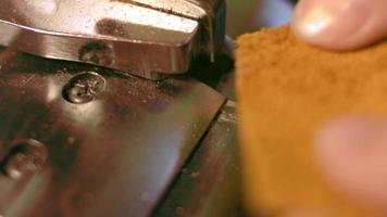 cucire macchina nel un' pelle laboratorio nel azione con mani Lavorando su un' pelle dettagli per scarpe. macro tiro di Da donna mani con cucire macchina a scarpe fabbrica video