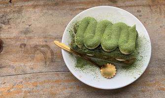 tiramisú matcha servido en una mesa de madera foto