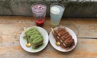 strawberry soda, lemon soda, chocolate tiramisu and matcha served on a wooden table photo