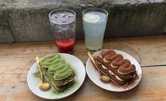 strawberry soda, lemon soda, chocolate tiramisu and matcha served on a wooden table photo