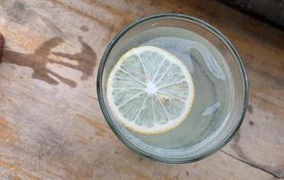 a glass of lemon soda seen from above, served on a wooden table photo