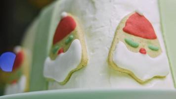 pastel de navidad con galletas de jengibre en forma de santa claus. ambiente festivo con velas y luces. video