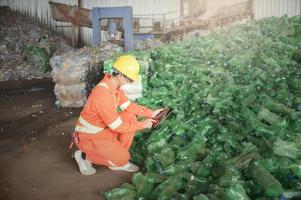 trabajador en una industria de reciclaje inspecciona el control de botellas de plástico utilizado en el proceso de reciclaje. foto