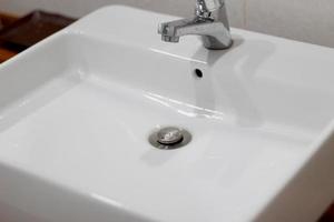 lavabo blanco con grifo gris foto