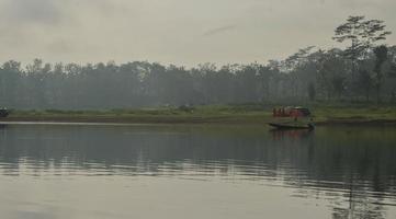 Malang,Indonesia - November 6th 2022 Asian fishermen looking for fish with a group of youths setting up tents on the lake shore photo