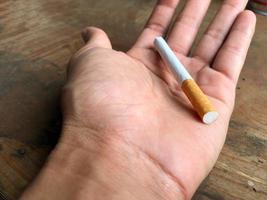 A cigarette in the palm of the hand photo