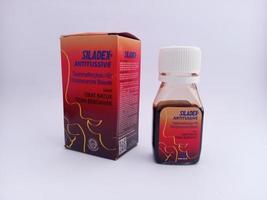 Malang, indonesia - November, 2022,  Cough syrup medicine with the siladex brand. Has a red packaging. With white isolated background photo