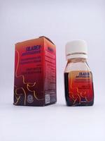 Malang, indonesia - November, 2022,  Cough syrup medicine with the siladex brand. Has a red packaging. With white isolated background photo