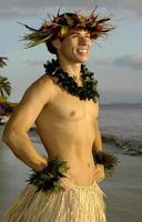 A smiling male hula dancer poses on beach at sunset. photo