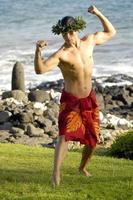 A masculine male hula dancer exhibits his traditional hula style. photo