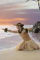 bailarín de hula masculino en la playa con un cielo de puesta de sol en el fondo