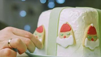 pastel de navidad con galletas de jengibre en forma de santa claus. ambiente festivo con velas y luces. video