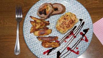 A beautifully decorated plate of food, fried meat and baked potatoes. video