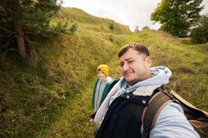 Father with son making selfie with backpack at forest. photo