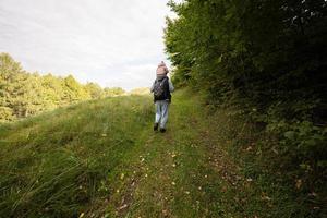 papá con hija sobre sus hombros caminando en el bosque. foto