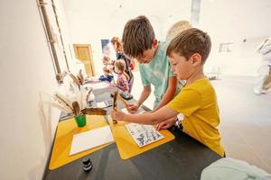 niños escribiendo con pluma de ave en el escritorio. foto