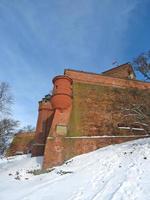 Red brick fortification walls underneath of the Thieves Tower . Plaque with the inscription Krakus Prince of Poland in memory of the victory over the Wawel Dragon. photo